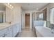 Bright bathroom featuring double sink vanity, soaking tub, and glass-enclosed shower at 124 Felicity Pike, Locust Grove, GA 30248