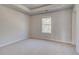 Bright bedroom featuring neutral walls, plush carpeting, tray ceiling, and natural light from a window at 124 Felicity Pike, Locust Grove, GA 30248