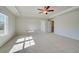 Spacious bedroom with neutral walls, plush carpet, tray ceiling and a ceiling fan at 124 Felicity Pike, Locust Grove, GA 30248