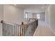 Upstairs hallway with modern wrought iron and wood railing and plush carpet at 124 Felicity Pike, Locust Grove, GA 30248