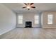 Bright living room featuring hardwood floors, a fireplace, and large windows at 124 Felicity Pike, Locust Grove, GA 30248