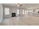 Spacious living room with fireplace, hardwood floors, and an open layout to the kitchen at 124 Felicity Pike, Locust Grove, GA 30248
