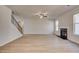 Spacious living room with a fireplace, fan, and a staircase to the second floor at 124 Felicity Pike, Locust Grove, GA 30248