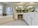 Bathroom showcases a large soaking tub, tiled floors, and white vanity at 253 Hailwood Ct, Suwanee, GA 30024