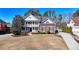 Angle view of a two-story brick home with a welcoming front porch, landscaping, and driveway at 253 Hailwood Ct, Suwanee, GA 30024