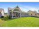 A large, grassy backyard features a covered patio with furniture and evenly spaced windows at 302 Bunker Hill Ct, Acworth, GA 30102