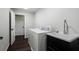 Functional laundry room features a washer and dryer and utility sink with black cabinetry and modern fixtures at 914 Adair Ne Ave, Atlanta, GA 30306