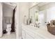 Neutral bathroom with a single sink vanity, a large mirror, and a bathtub with shower at 2310 Gracehaven Way, Lawrenceville, GA 30043