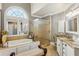 Bright bathroom features tub, frosted glass shower, and double sink vanity with granite countertops at 2310 Gracehaven Way, Lawrenceville, GA 30043