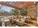 Comfortable covered patio with stone flooring, plush outdoor furniture, and a pergola roof at 2310 Gracehaven Way, Lawrenceville, GA 30043