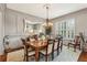Refined dining room with a decorative chandelier, classic wainscoting, and shuttered windows creating a sophisticated ambiance at 2310 Gracehaven Way, Lawrenceville, GA 30043