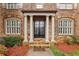 Elegant front entrance with stately columns, stone walkway, and a classic black double door design at 2310 Gracehaven Way, Lawrenceville, GA 30043