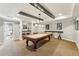 Well-appointed basement game room featuring a billiard table under pendant lighting, bar top seating, and neutral colors at 2310 Gracehaven Way, Lawrenceville, GA 30043
