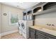 Bright laundry room featuring front load washer and dryer, built-in shelving, and a sink under the window at 2310 Gracehaven Way, Lawrenceville, GA 30043