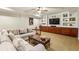 Basement living room with comfortable seating and a built-in entertainment center with display shelves at 2310 Gracehaven Way, Lawrenceville, GA 30043