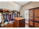 Large walk-in closet with extensive shelving, hanging racks, and a center island dresser at 2310 Gracehaven Way, Lawrenceville, GA 30043