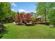 Expansive backyard with manicured lawn, mature trees, and outdoor deck at 1790 Mountain Farm Rd, Woodstock, GA 30188