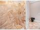 A luxurious walk-in shower with marble tiles, complemented by gold hardware and black fixtures at 1790 Mountain Farm Rd, Woodstock, GA 30188