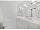 A pristine white bathroom with ample lighting, tile walls, and a coordinated vanity at 1790 Mountain Farm Rd, Woodstock, GA 30188