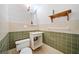 Cozy half-bath with a sink, toilet, and wooden shelf, perfect for guests at 1790 Mountain Farm Rd, Woodstock, GA 30188