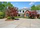 Stately home featuring a brick and white exterior, complemented by a circular driveway at 1790 Mountain Farm Rd, Woodstock, GA 30188
