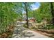 Long driveway leads to a large residence with a water feature surrounded by trees at 1790 Mountain Farm Rd, Woodstock, GA 30188
