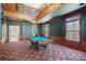 Spacious game room with pool table, large windows, custom woodwork, and colorful carpeting, providing a luxurious feel at 1790 Mountain Farm Rd, Woodstock, GA 30188