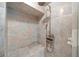 Modern shower features a rainfall shower head, handheld sprayer, a corner bench and niche, and decorative stone-look tiling at 1790 Mountain Farm Rd, Woodstock, GA 30188
