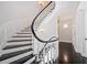 Elegant staircase with dark wood steps and white risers, illuminated by sconces at 1790 Mountain Farm Rd, Woodstock, GA 30188