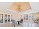 Elegant sunroom with walls of windows, chandelier, and neutral tones, offering an inviting space with picturesque views at 1790 Mountain Farm Rd, Woodstock, GA 30188