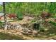 Backyard oasis featuring a stunning waterfall and stone landscaping in a lush, wooded setting at 1790 Mountain Farm Rd, Woodstock, GA 30188