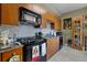 Galley kitchen featuring wood cabinets, black appliances and granite countertops providing a contemporary feel at 2626 Peachtree Nw Rd # 704, Atlanta, GA 30305