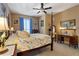 A spacious bedroom with a floral bedspread, a four-poster bed, and a window with blue curtains at 2626 Peachtree Nw Rd # 704, Atlanta, GA 30305