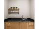 Chic bar area features black countertop, stainless steel fixtures, and decorative shelving at 2542 Maclaren Cir, Dunwoody, GA 30360