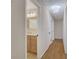 Hallway view to the bathroom featuring wood flooring, neutral walls and updated lighting at 2542 Maclaren Cir, Dunwoody, GA 30360