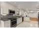 Open kitchen boasts white cabinets, granite counters, stainless appliances, and tile floor at 2542 Maclaren Cir, Dunwoody, GA 30360