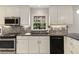 Close up on sink and countertop area with stainless steel appliances, white cabinets, and window at 2542 Maclaren Cir, Dunwoody, GA 30360