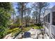 A charming backyard featuring a patio with Adirondack chairs, a playhouse, and a wooded backdrop at 6785 Wright Ne Rd, Atlanta, GA 30328