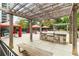 Outdoor kitchen with pergola, stone countertop, built-in grill, and nearby covered picnic areas at 795 Hammond Dr # 813, Sandy Springs, GA 30328