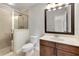 Modern bathroom featuring a glass shower, wood vanity, and a stylish mirror at 11894 Aspen Forest Dr, Johns Creek, GA 30005