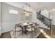 Bright dining room with modern chandelier, neutral tones, and views of the staircase at 11894 Aspen Forest Dr, Johns Creek, GA 30005