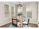 A dining room with a round table, four chairs, and lots of natural light at 11894 Aspen Forest Dr, Johns Creek, GA 30005