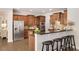 Well-equipped kitchen with stainless steel appliances, granite countertops, island with bar stools, and wood cabinets at 11894 Aspen Forest Dr, Johns Creek, GA 30005