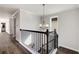 The stairwell has a decorative light fixture, wooden floors, and iron railings at 11894 Aspen Forest Dr, Johns Creek, GA 30005