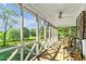 Screened-in porch with ceiling fan, black and white chairs, and scenic view at 161 Amy Ln, Canton, GA 30115