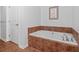 Bright bathroom featuring a soaking tub, tiled floor, and walls creating a relaxing and spa-like atmosphere at 2950 Mount Wilkinson Se Pkwy # 505, Atlanta, GA 30339