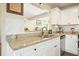 Kitchen detail featuring granite counters, white tile backsplash, stainless sink, and white cabinetry at 1750 Latour Ne Dr, Marietta, GA 30066