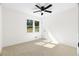 Bright bedroom with a ceiling fan, a large window overlooking the backyard, and neutral carpet at 215 Sabrina Ct, Woodstock, GA 30188