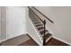 Stairway with wood stairs, white risers, dark metal balusters, and a stained newel post near a white door at 2478 Georgetown Ave, Atlanta, GA 30345