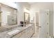 Well-lit bathroom featuring double sinks, granite countertops, and a glass-enclosed shower at 105 Ivey Way, Woodstock, GA 30188